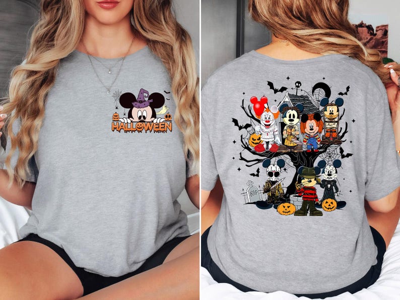 May include: Gray t-shirt with a Halloween themed design. The front of the shirt features Mickey Mouse wearing a witch hat and the text "HALLOWEEN". The back of the shirt features Mickey Mouse and friends in a spooky setting with a haunted house and a graveyard.