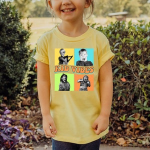 May include: A yellow t-shirt with a colorful graphic of four kids from the movie Home Alone. The graphic includes the text "Kid Vibes".