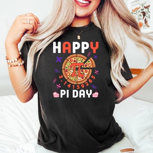 May include: Black t-shirt with a graphic of a pizza slice with the mathematical symbol pi and the text "Happy Pi Day".