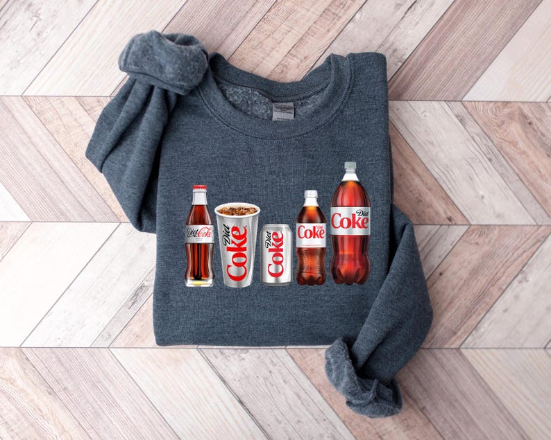 May include: A dark grey sweatshirt with a graphic of five different Coca-Cola products, including a glass bottle, a can and a plastic bottle. The text "Diet Coke" is visible on the graphic.