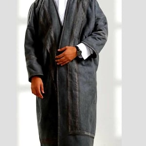May include: A long, dark gray robe with intricate embroidered detailing down the front and on the sleeves. The robe is worn over a white collared shirt. The garment has a relaxed fit and appears to be made of a soft fabric.