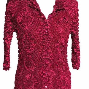 May include: A maroon, textured, button-up shirt with a ruffled collar and three-quarter sleeves.