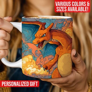 Könnte beinhalten: Weißer Keramikbecher mit einer lebendigen Illustration von Charizard. Das Design zeigt das Feuer-Pokémon in Orange, Blau und Gelb, mit dem Text "PERSONALIZED GIFT" unten und "VARIOUS COLORS & SIZES AVAILABLE!" oben.