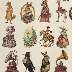 Pu&ograve; includere: Una collezione di adesivi in stile vintage con vari animali e oggetti antropomorfi. Gli adesivi includono un cane, un coniglio, una volpe e un elefante, vestiti con abiti vittoriani, insieme a una tazza da t&egrave;, un grammofono e un mappamondo.