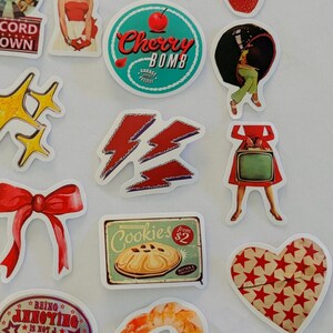 May include: A collection of assorted die-cut stickers featuring various illustrations including a vintage television, a mailbox, a cat eating chips, sliced strawberries, a cherry bomb logo, a red bow, a cookie sign, and a pair of red lips.