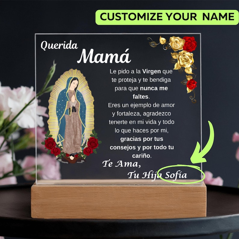 May include: A personalized acrylic plaque with a wooden base. The plaque features an image of the Virgin Mary, red and gold roses, and text in Spanish. The text includes the words "Querida Mam&aacute;" and "Te Ama, Tu Hija Sofia".