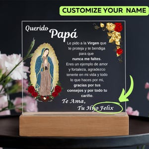 May include: A glass plaque with a wooden base features a religious image of the Virgin Mary with a gold halo. The plaque has a message in Spanish that reads "Querido Papá Le pido a la Virgen que te proteja y te bendiga para que nunca me faltes. Eres un ejemplo de amor y fortaleza, agradezco tenerte en mi vida y todo lo que haces por mi, gracias por tus consejos y por todo tu cariño. Te Ama, Tu Hijo Felix".