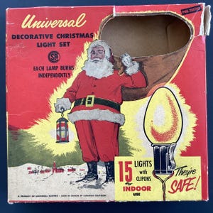 May include: A red and white box featuring a Santa Claus illustration holding a bag of gifts. The box contains a pre-tested decorative Christmas light set with 15 lights and clip-ons for indoor use. The text on the box reads "Universal Decorative Christmas Light Set" and "They're Safe!"