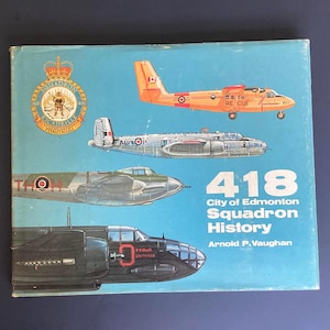 Peut inclure: Couverture de livre vintage avec des illustrations d'avions en vol, dont un avion orange avec le texte "RESCUE". La couverture présente également le texte "418 City of Edmonton Squadron History" et un emblème d'escadron.
