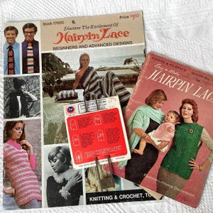 May include: Two vintage instructional booklets titled Hairpin Lace, featuring photography of models wearing crocheted garments, alongside a small red and white Boye brand metal hairpin lace tool with printed diagrams and instructions.