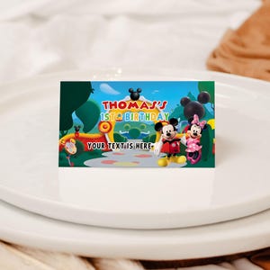 May include: A rectangular card featuring Mickey and Minnie Mouse with the text "Thomas's 1st Birthday" against a colorful cartoon landscape. The card includes the text "Your text is here".