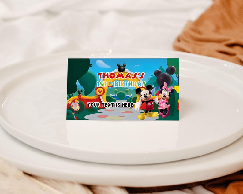 May include: A rectangular card featuring Mickey and Minnie Mouse with the text "Thomas's 1st Birthday" against a colorful cartoon landscape. The card includes the text "Your text is here".
