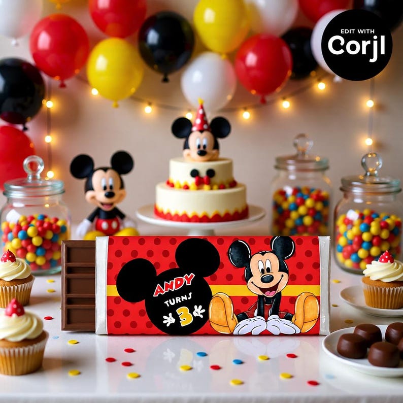 以下が含まれることがあります： ミッキーマウスをテーマにしたお祝いの誕生日シーン。ミッキーマウスと「Andy Turns 3」の文字が描かれた赤い包装紙のチョコレートバーが中心です。風船、ケーキ、カップケーキ、お菓子がパーティーを盛り上げます。