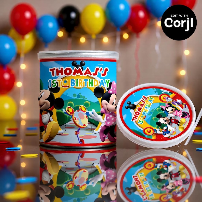 May include: A cylindrical container and lid with a Mickey Mouse theme, featuring Mickey and Minnie Mouse. The container is blue with the text "THOMAS'S 1ST BIRTHDAY". Balloons in red, blue, yellow, and black are in the background.