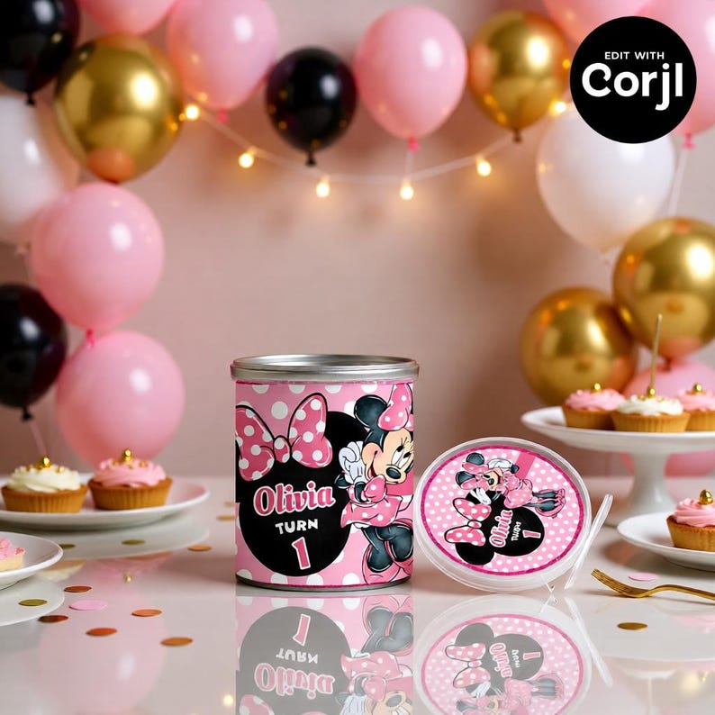 May include: A pink and black Minnie Mouse-themed birthday party decoration. The centerpiece is a cylindrical container with a Minnie Mouse graphic, the name "Olivia", and the number "1". The scene includes balloons and cupcakes.