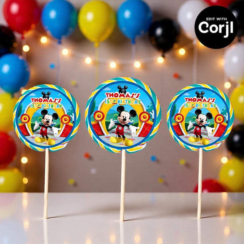 May include: Three Mickey Mouse-themed lollipop decorations for a birthday party. Each lollipop features a circular design with Mickey Mouse, the text "THOMAS'S 1ST BIRTHDAY", and a colorful border. The lollipops are on wooden sticks.