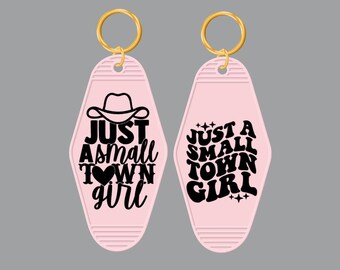 May include: Two pink motel keychains with gold key rings. One keychain says "Just a small town girl" with a heart and the other says "Just a small town girl" with a cowboy hat.