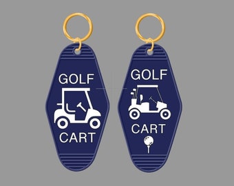 May include: Two blue keychains with gold rings. Each keychain has a white golf cart and the text "GOLF CART". One keychain also has a white golf ball on a tee.