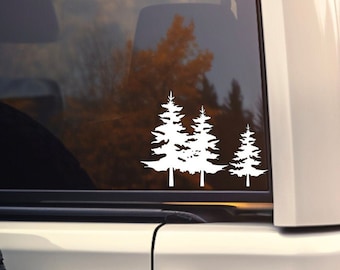 May include: White vinyl decal of three pine trees on the back window of a white SUV.