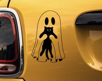 May include: A black vinyl decal featuring a ghost silhouette with two oval eyes, holding a small black cat in its arms. The design is applied to a smooth yellow surface, showcasing clean lines and a simple graphic representation of a ghost and cat.