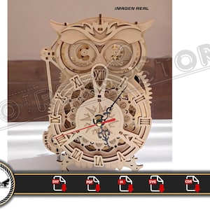 May include: Wooden owl-shaped clock with detailed gears and clock face. The clock has Roman numerals and a compass rose design. The hands are black and red. The image includes the text "IMAGEN REAL".