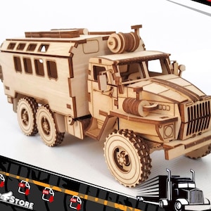 May include: A wooden model kit of a large, off-road truck with a flatbed and a hose reel on the back. The truck is made of laser-cut wood and is ready to be assembled.