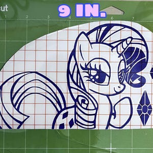Pu&ograve; includere: Un adesivo in vinile blu e bianco di un pony dei cartoni animati con un simbolo di diamante. L'adesivo misura 23 cm di larghezza e 13 cm di altezza.