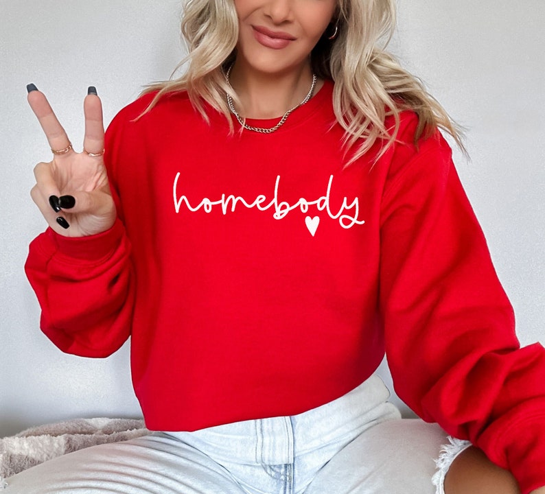 May include: Red cropped sweatshirt with the text "homebody" in white lettering and a small white heart.