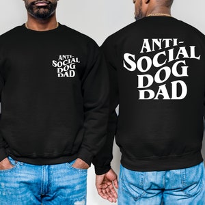 Pu&ograve; includere: Felpa nera con testo bianco che recita "Anti-Social Dog Dad" sul retro e "Anti-Social Dog Dad" impilato verticalmente sul davanti.