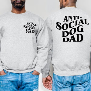 Pu&ograve; includere: Una felpa grigia con il testo "ANTI-SOCIAL DOG DAD" stampato in nero sul retro. Lo stesso testo &egrave; stampato in un formato pi&ugrave; piccolo sul davanti della felpa.