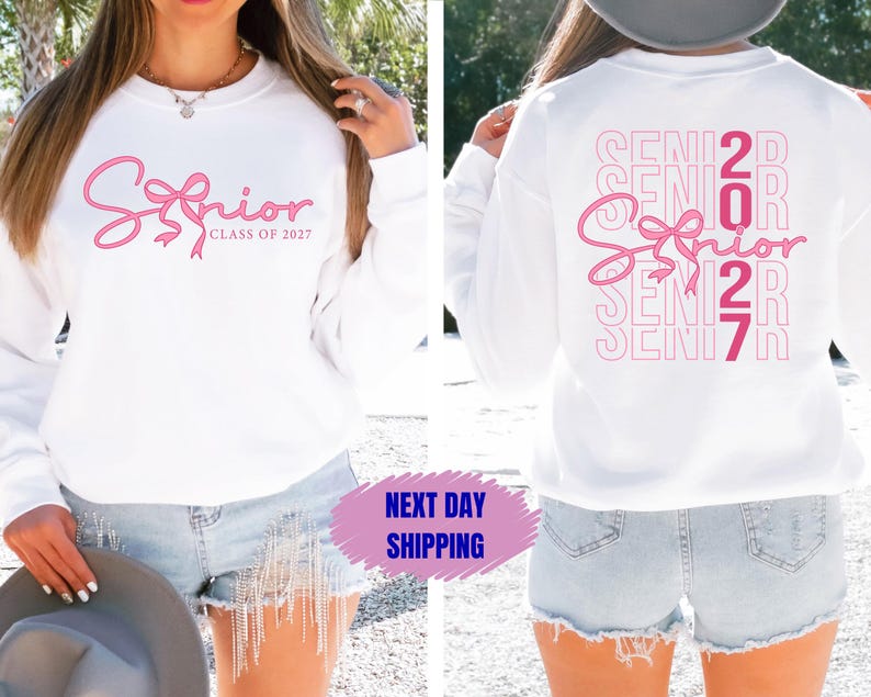 May include: White sweatshirt with the word "Senior" in pink script and a bow design. The text "Class of 2027" is below the word "Senior". The back of the sweatshirt has the word "Senior" repeated vertically with the numbers "2027".