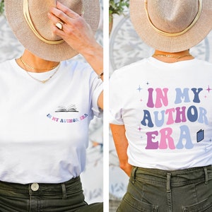 Puede incluir: Camiseta blanca con un gr&aacute;fico de un libro y el texto "In My Author Era" en la parte delantera y el texto "In My Author Era" con un gr&aacute;fico de libro en la parte posterior.