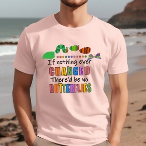 May include: Pink t-shirt featuring a colourful graphic of a caterpillar transforming into a butterfly. The text reads "If nothing ever CHANGED There'd be no BUTTERFLIES".