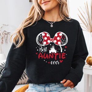 May include: Black sweatshirt with a graphic featuring Minnie Mouse ears with red polka dots, a castle, and the text "Best Auntie ever" in red. The design includes hearts and stars.