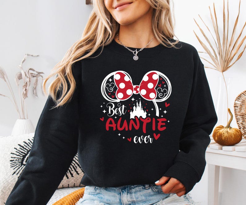 May include: Black sweatshirt with a graphic featuring Minnie Mouse ears with red polka dots, a castle, and the text "Best Auntie ever" in red. The design includes hearts and stars.
