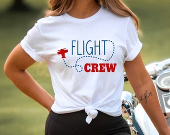 May include: White t-shirt with a red airplane graphic and the text "FLIGHT CREW" in blue and red.
