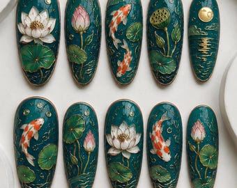 May include: A set of ten almond-shaped press-on nails featuring a deep teal background with raised gold-lined designs of white lotus flowers, pink lotus buds, green lily pads, orange and white koi fish, and a golden moon over water.