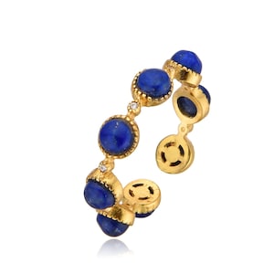 Op de afbeelding: Gouden ring met blauwe lapis lazuli stenen en kleine heldere diamanten.