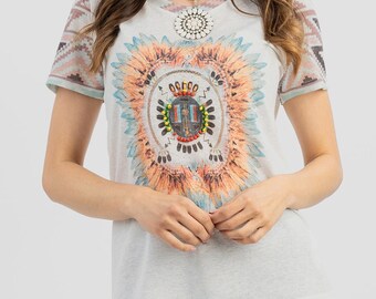 May include: White t-shirt with a colorful Native American inspired design featuring feathers and a beaded shield. The shirt has a short sleeve and a crew neck.