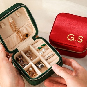 a person holding a case with jewelry inside of it