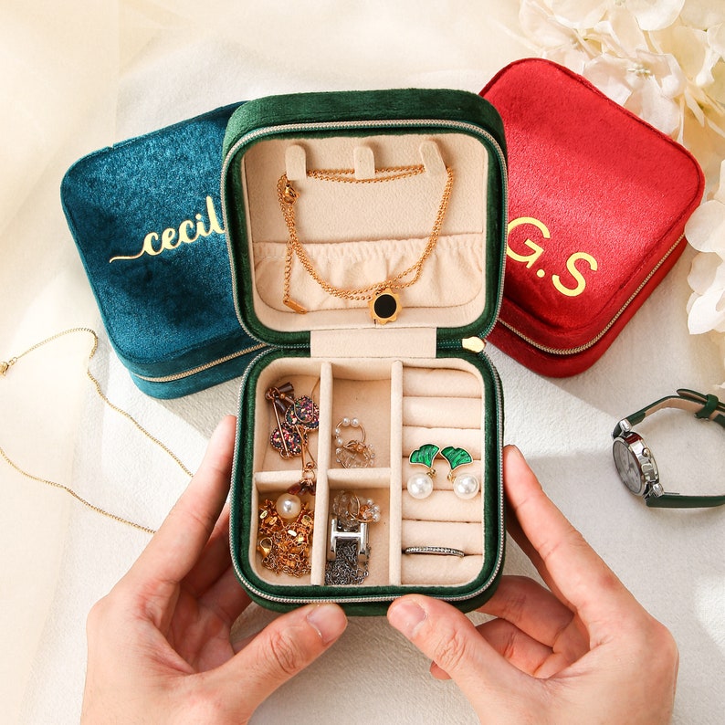 a person holding a green case filled with jewelry