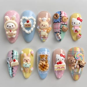Może przedstawiać: Zestaw dziesięciu sztucznych paznokci w kształcie migdałów z ozdobami 3D, w tym króliczkami, misiami, figurkami Hello Kitty, ciastami, goframi, lodami w rożku i lizakami. Wzory zawierają pastelowe kolory, kratkę i kropki.