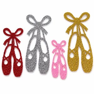 May include: Four glittery ballet slipper cutouts arranged in a row. The set includes one red, one silver, one pink, and one gold pair of shoes. Each pair features a decorative bow at the top and a classic ballet slipper silhouette with cutouts.