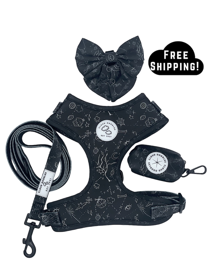 May include: A black dog harness set with a matching bow tie, lead, and waste bag dispenser. The set features a white pattern of stars, clouds, and other shapes. The lead and waste bag dispenser have the text "Cloud Doodles Est 2021".