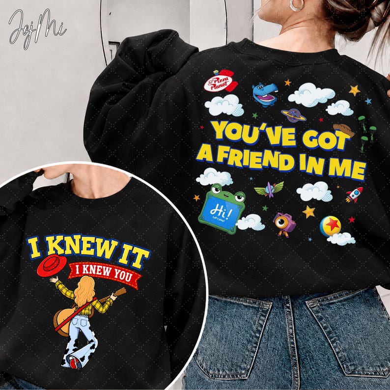 May include: A black crewneck sweatshirt featuring two distinct graphic designs. The back displays the text "YOU'VE GOT A FRIEND IN ME" with cartoon icons, while the front shows a person playing a guitar with the text "I KNEW IT I KNEW YOU".
