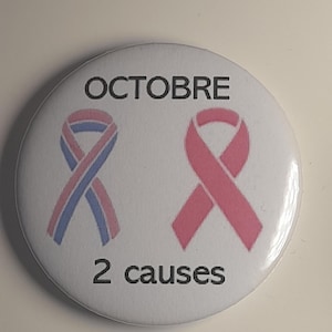 Może przedstawiać: Biały guzik z napisem "OCTOBRE" na górze i "2 causes" na dole. Guzik przedstawia dwa wzory wstążek, jeden różowy, a drugi niebiesko-różowy, symbolizujące świadomość.