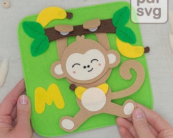 May include: A felt monkey hanging from a brown branch with bananas and green leaves, set against a green background. The monkey has a smiling face and is holding a banana. The letter "M" is also on the green background. The image has the text "pdf svg".