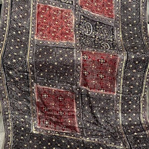 K&ouml;nnte beinhalten: Schwarzer Stoff mit einem Patchwork-Design mit roten und schwarzen Quadraten. Die Quadrate sind mit goldfarbenen Verzierungen und Mustern verziert. Der Text "Black base 2" ist in der oberen linken Ecke sichtbar.