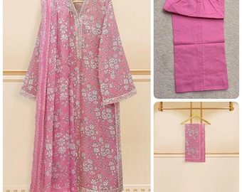 May include: A pink floral print kurta with a matching pink dupatta and pants. The kurta has a white lace trim and the dupatta is sheer.