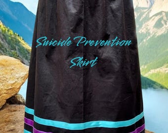 May include: Black skirt with teal and purple ribbon trim. The skirt has the text "Suicide Prevention Skirt" printed on it.